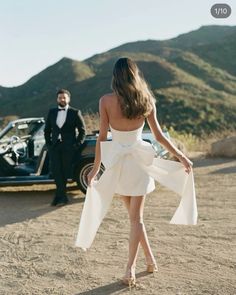 a man in a tuxedo standing next to a woman in a white dress