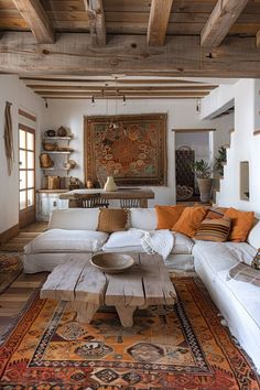 a living room filled with white furniture and lots of wood beams on the ceiling,