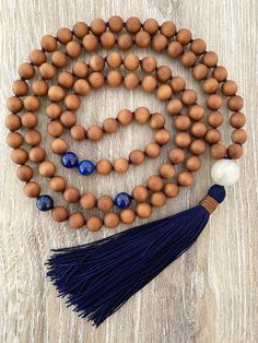 Sandalwood is a fragrant and soothing bead that is very calming to the mind. This mala is made up of mostly sandalwood, with Lapis Lazuli markers at the 27th and 54th positions. A moonstone guru bead sits on top of the handmade navy silk tassel. Such a neutral and earthy mala that feels great to wear and use for meditation. 8mm Sandalwood8mm Lapis Lazuli12mm MoonstoneNavy CordSilk Tassel Each mala I make comes shipped in a beautiful Mala Bag for safe keeping. Properties of the Stones in this Mal Traditional Mala With Natural Stones For Meditation, Traditional Mala With Large Beads For Meditation, Spiritual Blue Mala With 108 Beads, Inner Child Work, Beaded Amulet Mala For Meditation, Sandalwood Mala, Mala Necklace, Ancient Cultures, Feeling Great