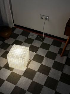 a lamp that is on top of a checkered floor in the middle of a room