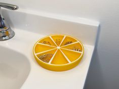 an orange slice sitting on top of a sink