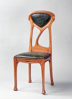 an antique chair with leather seat and back