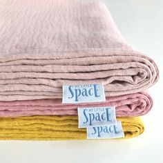 three different colored towels are stacked on top of each other, with the words space between them