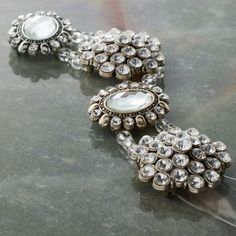 two brooches sitting on top of a table next to each other with stones