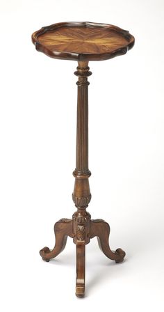 an antique wooden table with carved legs and a circular tray on the top that is turned upside down