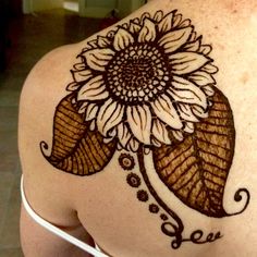 a woman's back with a sunflower tattoo on it