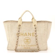 This is an authentic CHANEL Canvas Large Deauville Tote in Ivory. This stylish tote is crafted of fine canvas in white with gold printed Chanel Rue Cambon Paris logo. It features rolled leather top handles and fabric threaded gold chain shoulder straps. The top is open to a light beige fabric interior with zipper and patch pockets. Chanel Rue Cambon, Chanel Canvas, Paris Logo, Beige Fabric, Gold Print, Leather Top, Light Beige, Gold Chain, Patch Pocket