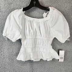 Habitual Ruffle Top Girls' 10 White Elasticized Ruffled Neckline Raglan Sleeves Habitual Ruffle Top Girls' 10 White Elasticized Ruffled Neckline Raglan Sleeves Retail $48.00 Make Your Little Girl Stand Out In This Beautiful White Ruffle Top From Habitual. The Top Features A Scoop Neckline With Elasticized Ruffles And Short Raglan Sleeves. It Is Made Of A Blended Fabric Consisting Of Nylon, Cotton, And Elastane, Making It Breathable And Perfect For Summer Or Spring. This Casual Top Is Easy T White Smocked Top With Ruffles And Short Sleeves, White Puff Sleeve Top With Ruffles, Ruffle Shirts, Ruffled Tops, White Ruffle Top, Top Girls, Ruffled Neckline, Girl Standing, Frill Sleeves