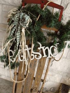 a wooden sled with a wreath hanging on it's side next to a brick wall