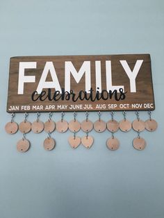 a wooden sign that says family celebrations hanging on a wall with lots of coins attached to it