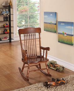 a wooden rocking chair sitting on top of a hard wood floor next to a toy car