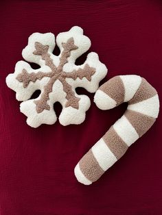 two snowflakes are placed next to each other on a red shirt with white and brown stripes