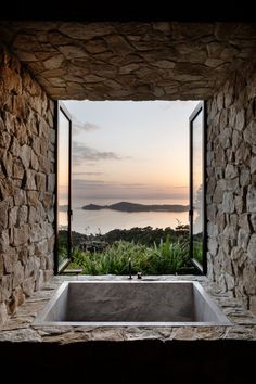 a large stone bath tub sitting under a window