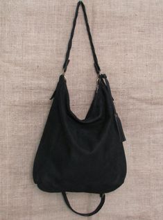 Handmade black suede hobo bag. This bag is unlined, inside there is a big cotton zipped pocket. The bag is closed with a zip The handle is an handmade leather braid. The sholder belt is removable and adjustable. This confortable hobo bag is very practical for any occasion. This bag is very large and soft and may contain many things. Features : - Black suede, - Unined, - Metal finishes are brass colored, - Closed with zip, - Inside zipped pocket, - Removable shoulder belt. Size : - Heigth 16 inch Versatile Suede Hobo Bag With Soft Leather, Versatile Suede Hobo Bag With Soft Leather Details, Black Suede Bag With Detachable Strap, Suede Hobo Bag With Zipper For Everyday Use, Everyday Suede Hobo Bag With Zipper Closure, Suede Hobo Shoulder Bag With Zipper, Suede Hobo Shoulder Bag With Zipper Closure, Suede Hobo Bag With Zipper For Daily Use, Suede Hobo Bag With Zipper Closure For Daily Use