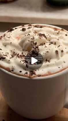 a white cup filled with whipped cream and chocolate