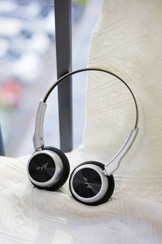 two headphones sitting on top of a bed next to a window