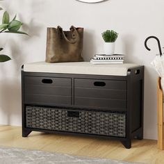 a black storage bench with two baskets on top and a brown bag next to it