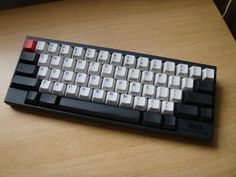 a computer keyboard sitting on top of a wooden table