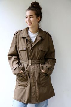 Vintage trench coat in brown khaki military-style, short length, original belt attach, pockets, buttons down the front- upper button is missing, original tag intact, fully lined in gold satin. aside from minor signs of wear, very good vintage condition clean ready to wear.   The model is 5'8" and size S/M for reference.Tag size: 48 Approximate size: O.S- please refer to the measurementsM E A S U R E M E N T S -were taken with garments laying flat, please double where necessary.————————————♥————B Brown Military Style Outerwear For Work, Vintage Belted Workwear Outerwear, Vintage Belted Outerwear For Work, Vintage Olive Outerwear For Work, Khaki Belted Utility Outerwear, Chunky Sweater Dress, Mustard Jumpsuit, Hippy Dress, Trench Coat Vintage