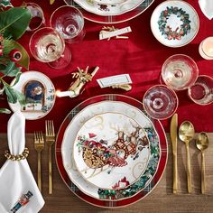 a christmas table setting with plates, silverware and napkins