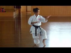 a woman is practicing karate in a gym