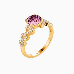 a yellow gold ring with an oval cut pink sapphire and diamonds on the sides, set in