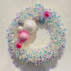 a christmas wreath with ornaments hanging from it