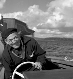 an old man is sitting in a boat with a horse on the front and steering wheel