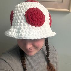 a girl wearing a white and red crocheted hat