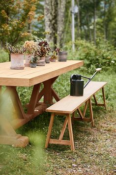 a picnic table with two benches and potted plants