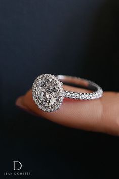 a close up of a person's hand holding a diamond ring