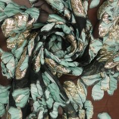 a scarf with gold and green leaves on it