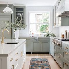 a kitchen with green cabinets, white counter tops and an area rug on the floor