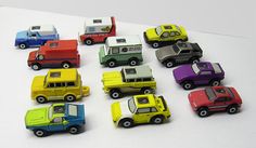 many different colored toy cars on a white surface