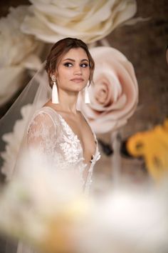 a woman in a wedding dress standing next to flowers