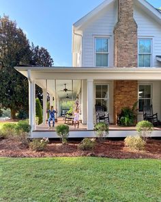 two people are standing on the front porch of a house