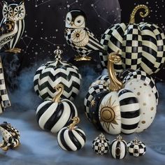 black and white pumpkins with gold accents are on display in front of an artistic backdrop