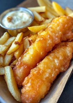 fish and fries on a plate with dipping sauce