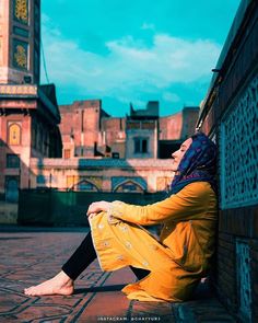 a woman sitting on the side of a building