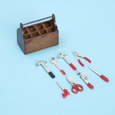 a wooden box filled with tools on top of a blue surface