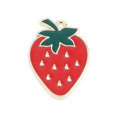 a red strawberry pin with green leaves on it's back and white dots around the bottom