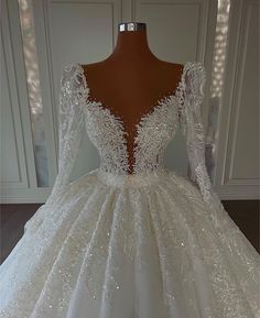 a white wedding dress with long sleeves and sequins