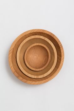 three wooden bowls sitting side by side on top of each other in the shape of circles