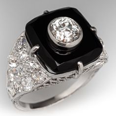 This awesome circa 1920s Art Deco dinner ring is centered with a rectangular onyx tablet in a four-prong setting. The center of the onyx is bezel set with one (1) old mine cut diamond, weighing 0.87 carats. The shoulders are each bead set with ten (10) antique cut diamonds. The ring measures 15.6mm at the top, rises 9.9mm above the finger, tapering to 1.7mm wide and 1.0mm thick at the base of the shank.  It is currently a size 7.75. Formal Art Deco Rings With Black Enamel, Art Deco Black Enamel Rings For Formal Occasions, Classic Onyx Diamond Ring, Vintage Black Diamond Ring With Diamond Accents, Elegant Black Rectangular Signet Ring, Elegant Signet Ring With Rectangular Gemstone, Black Art Deco Signet Ring For Anniversary, Antique Black Diamond Ring For Formal Occasions, Art Deco Rings With Rectangular Stone For Formal Occasions