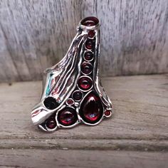 Amir Poran Design------A long finger ring  with  GARNET  stones and 3 CZ( garnet) Description Length--1.57 inches Max width--1.18 inches Matching bracelet: https://www.etsy.com/il-en/listing/1091372619/silver-big-cuff-bracelet-multi-stone?click_key=8237349103ec7740c3e2d52ca3a95c0572d66335%3A1091372619&click_sum=daf6f63d&ref=shop_home_active_31&pro=1&frs=1&sts=1 An amazing gift for yourself or loved ones!  Comes in a beautiful jewelry gift box.  For more information see our shop policies.  Got an Carnelian Ring, Silver Ring Set, Carnelian Stone, Textured Ring, Garnet Ring, Matching Bracelet, Garnet Stone, Garnet Rings, Ring Unique