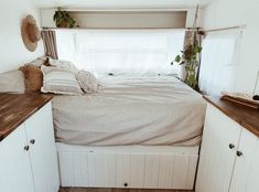 a bed sitting in the corner of a room next to a window