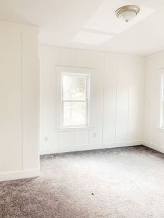 an empty room with white walls and carpet