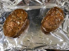 two loafs of bread sitting on top of aluminum foil