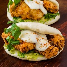 two tacos filled with chicken, lettuce and sour cream