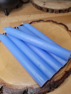 several blue candles sitting on top of a piece of wood